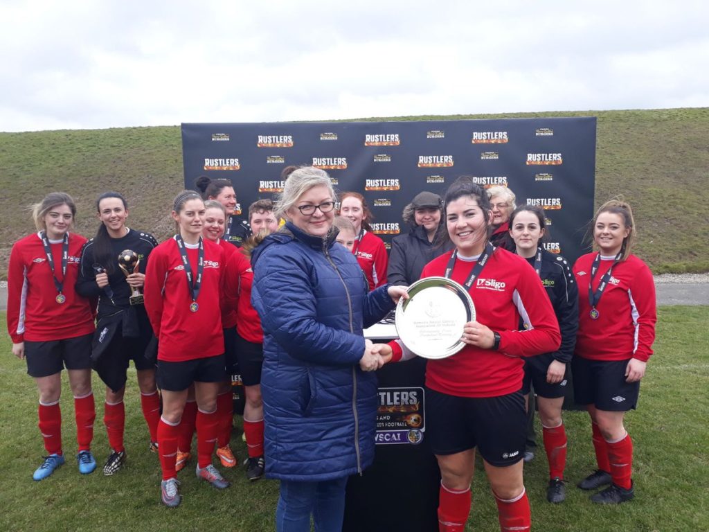 IT Sligo captain Rachel Kearns is presented with the trophy by Deirdre Hammond, the mother of the late Eithne Lydon who the Plate is named after.